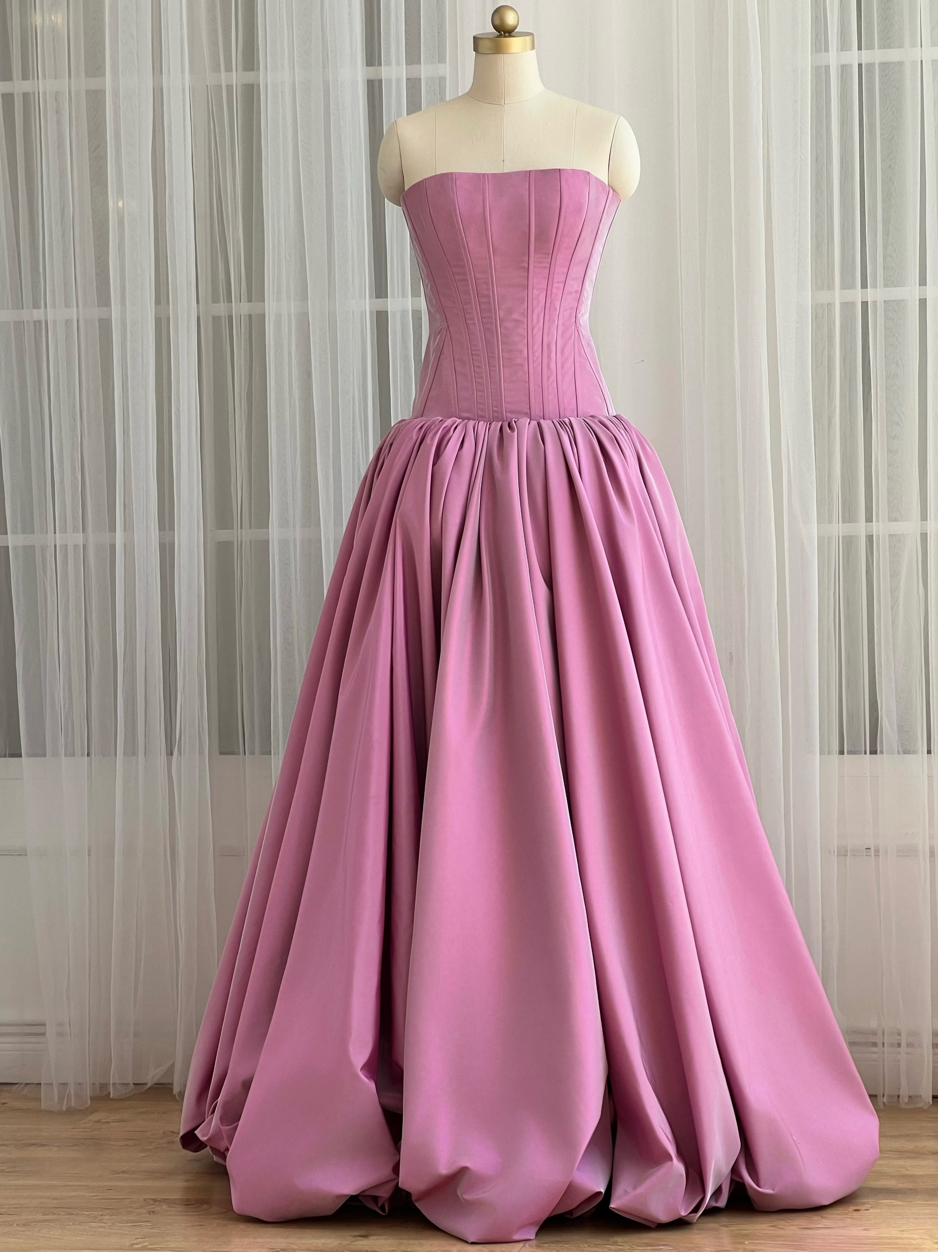 Pink strapless maxi dress with a fitted bodice and flared skirt