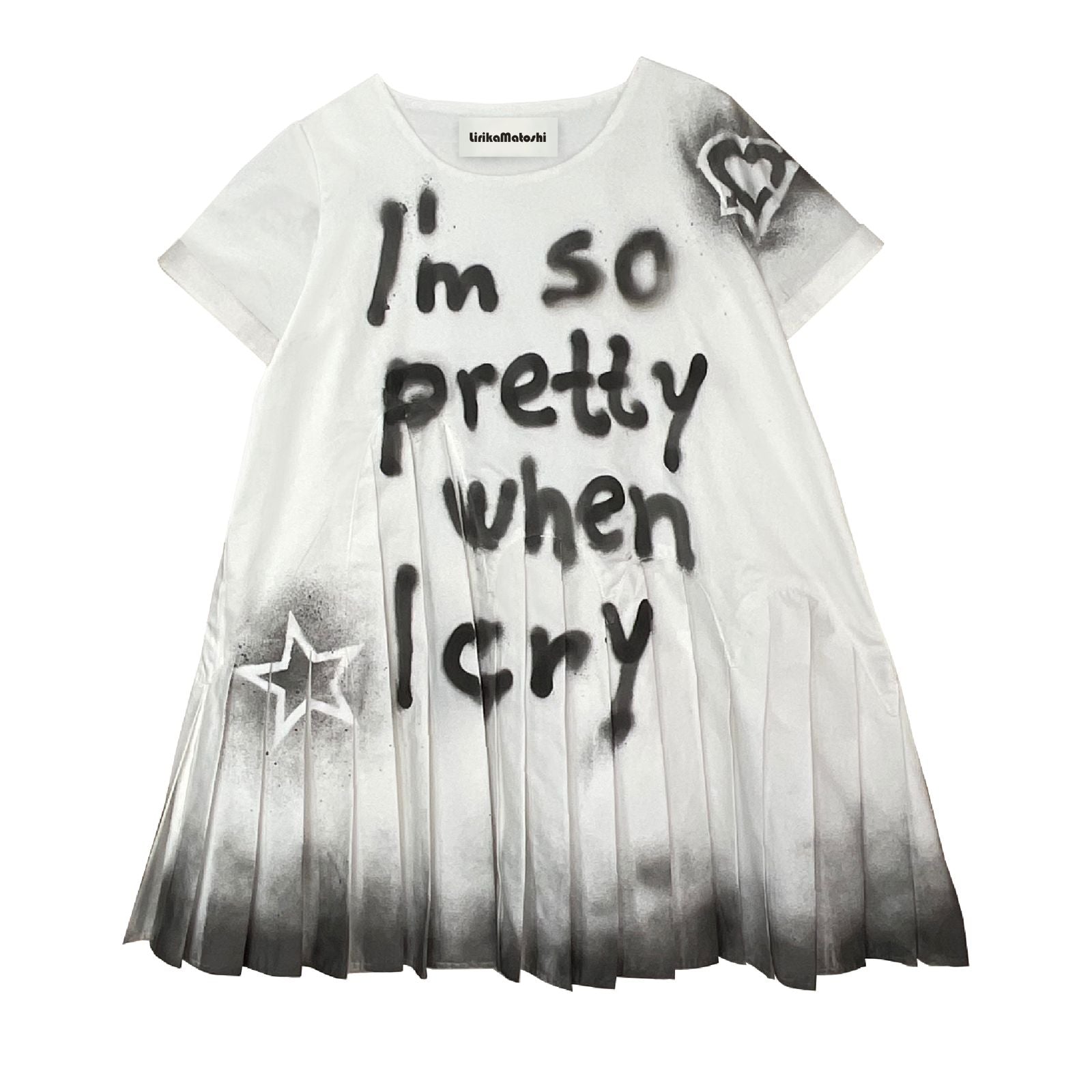 A black and white dress with pleated skirt and t-shirt bodice. The text 'I'm so pretty when I cry' is printed on the front, alongside star shapes.