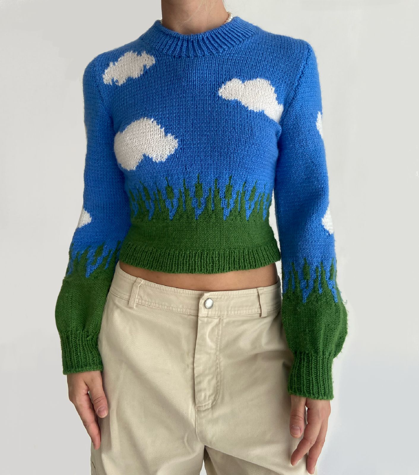 Blue knitted sweater with cloud and grass pattern