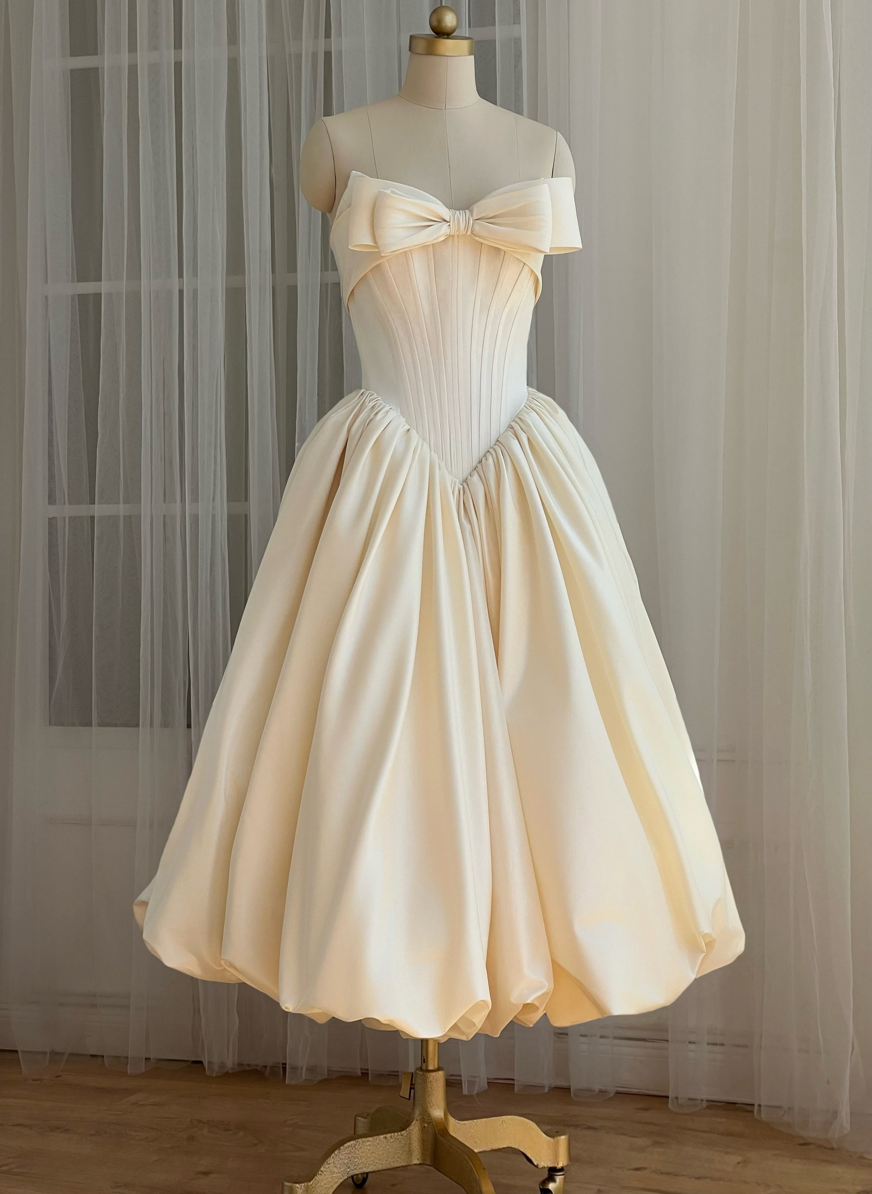 Cream-colored strapless dress with a large bow detail