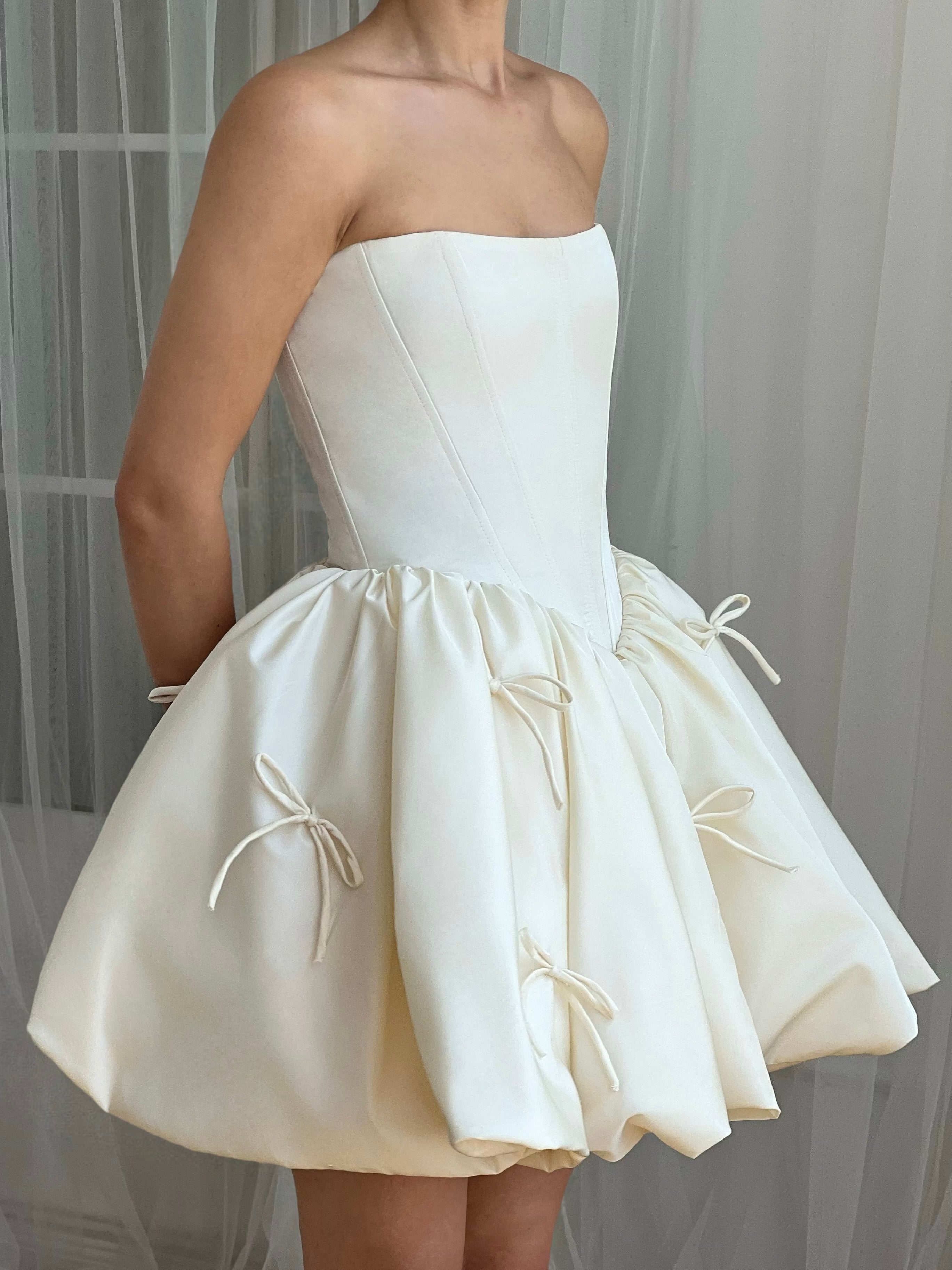 White mini dress with embroidered bows and no sleeves