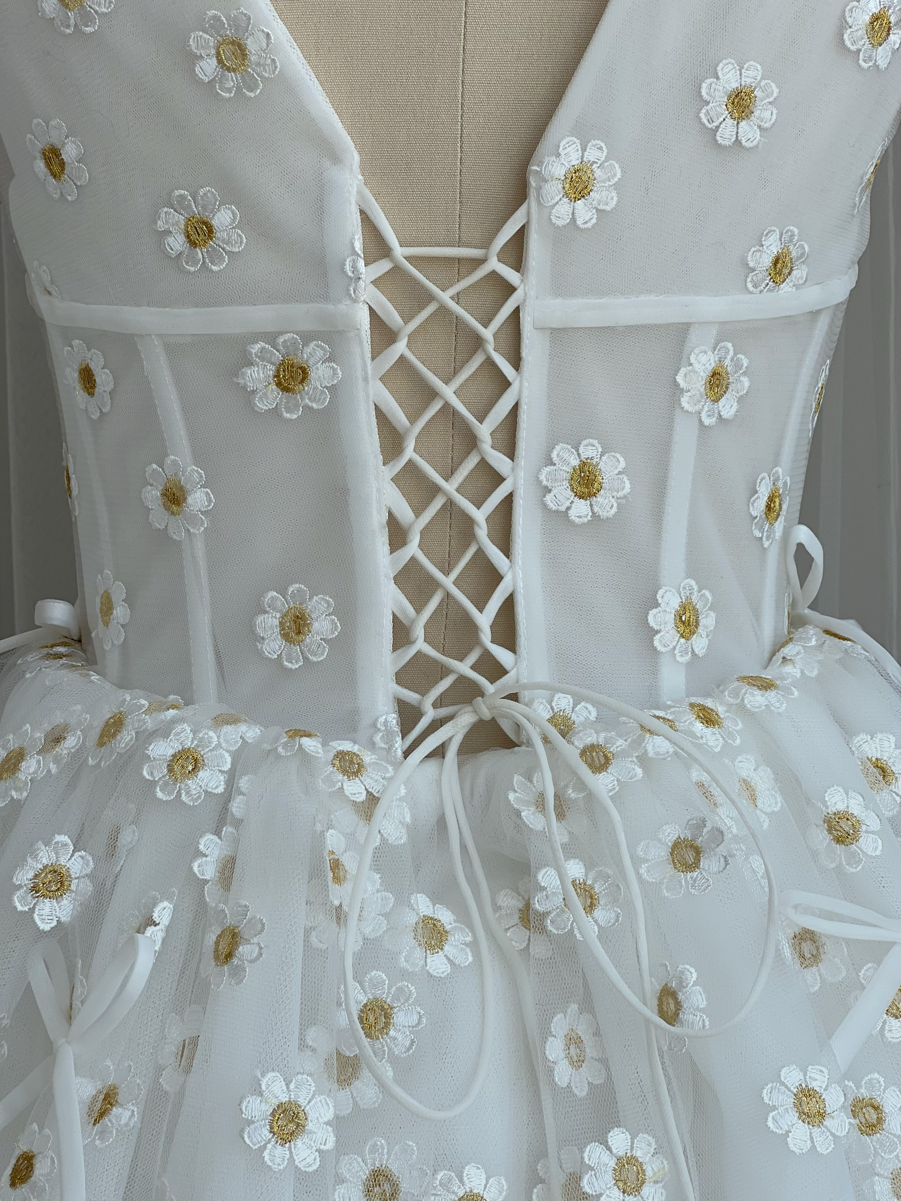 White mini dress with embroidered daisies, v-neck and short sleeves
