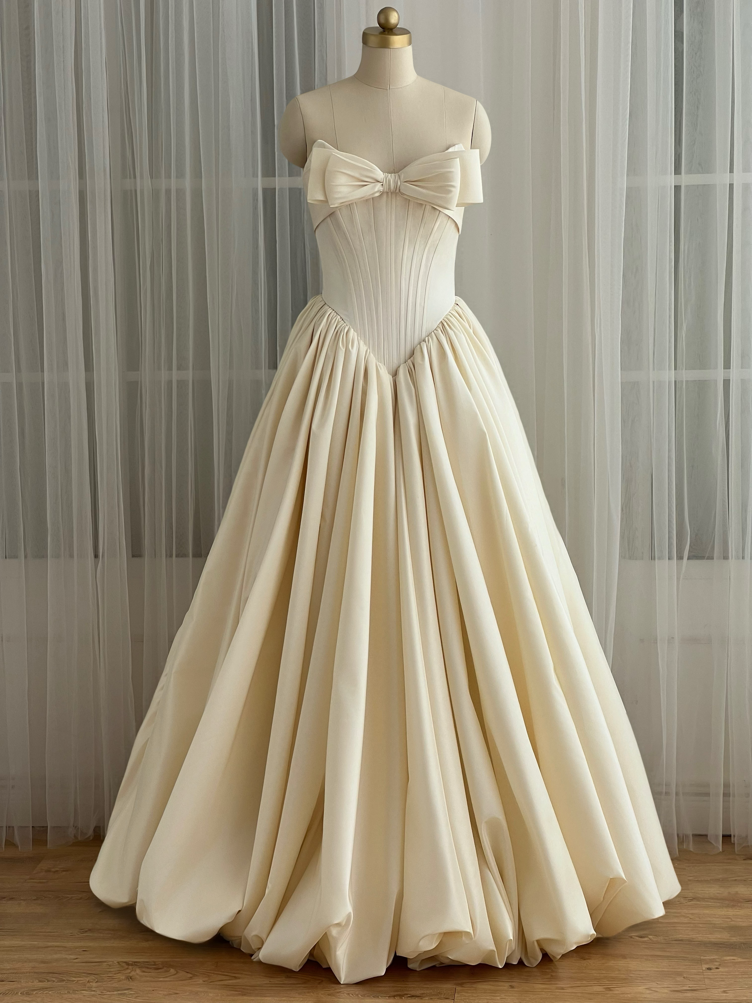 Beige evening gown with a large bow detail
